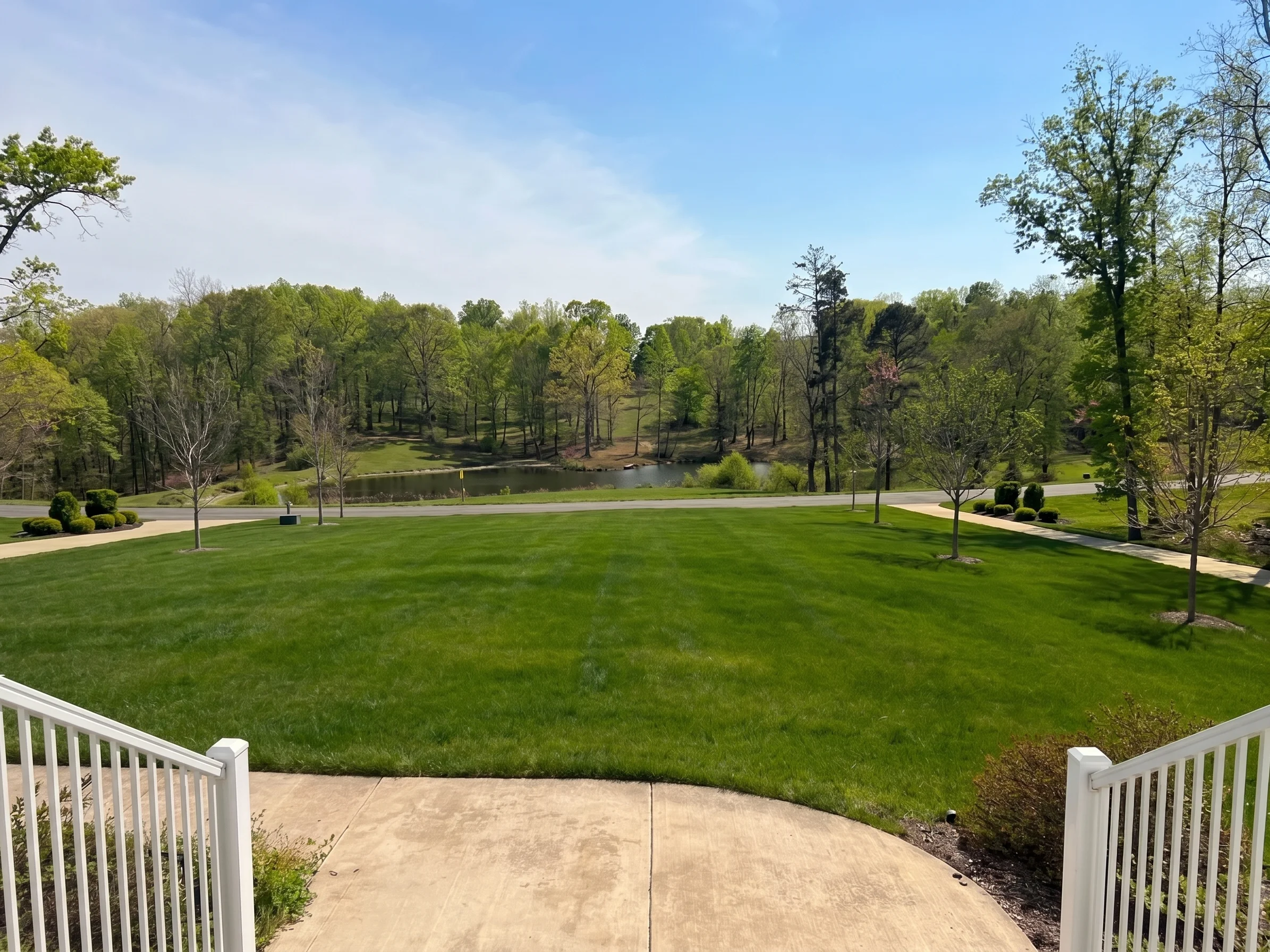 A wide green community lawn overlooking a pond in Carmel