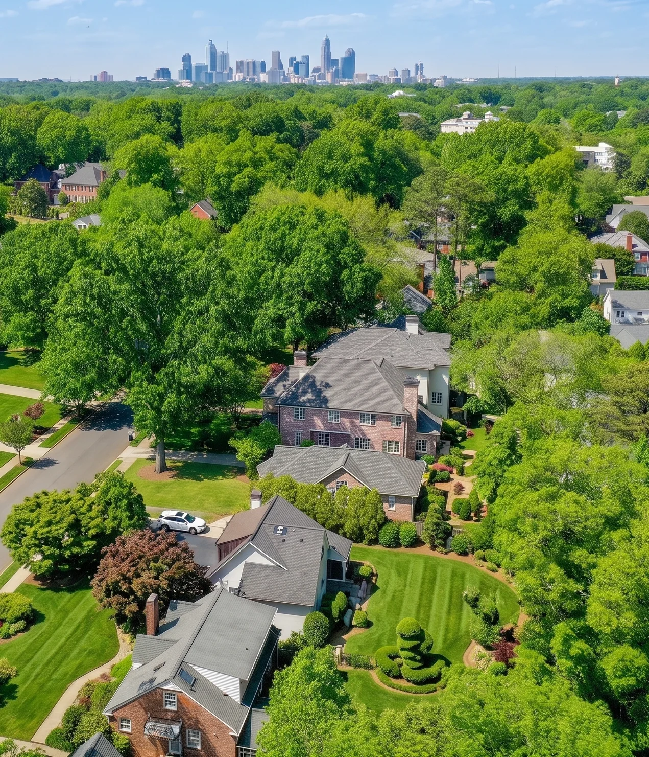 An aerial view of Myers Park homes and lawns with the Charlotte skyline